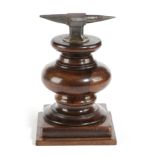 A VICTORIAN TREEN ROSEWOOD AND IRON JEWELLER'S ANVIL MID-19TH CENTURY on a turned stem and stepped