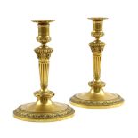 A PAIR OF EMPIRE ORMOLU CANDLESTICKS EARLY 19TH CENTURY each with a removable drip-tray above an urn