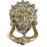 A BRASS DOOR KNOCKER MID-19TH CENTURY in the form of a lion's mask 24.5cm high, 14cm wide