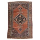 A HAMADAN RUG NORTH PERSIA / KURDISTAN, C.1920 the abrashed brick red field centred by an indigo