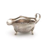 By A E Jones, an Arts and Crafts silver sauce boat, Birmingham 1929, oval form, spot-hammered
