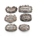 A collection of six antique silver wine labels, of shaped rectangular and oblong form, with foliate,
