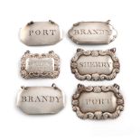 A collection of six antique silver wine labels, comprising: a pair by Kirby, Waterhouse and Co.,