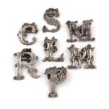 A collection of seven 19th century silver 'Cut-out letter' wine labels, comprising a set of three