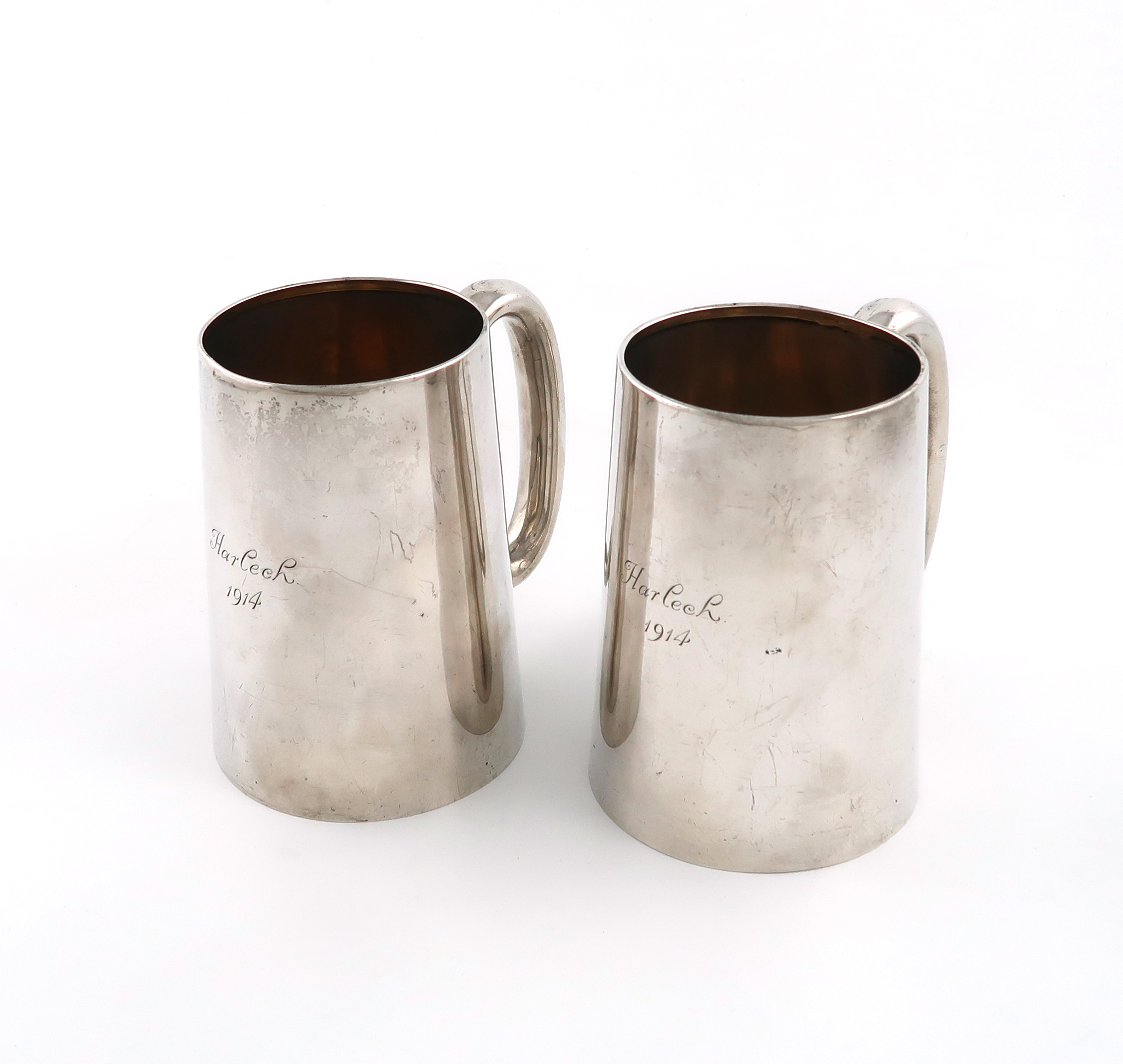 A pair of silver mugs, by William Hutton & Sons, Sheffield 1913, tapering circular form, scroll