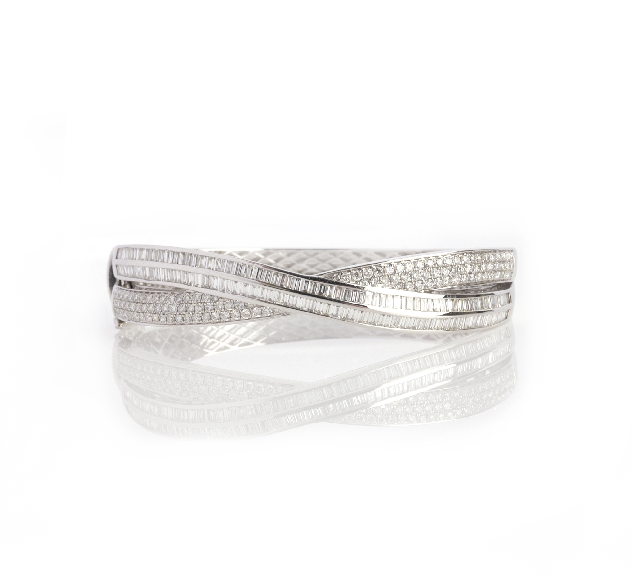 A diamond bangle, the hinged bangle of crossover design, the front section pavé-set with brilliant-