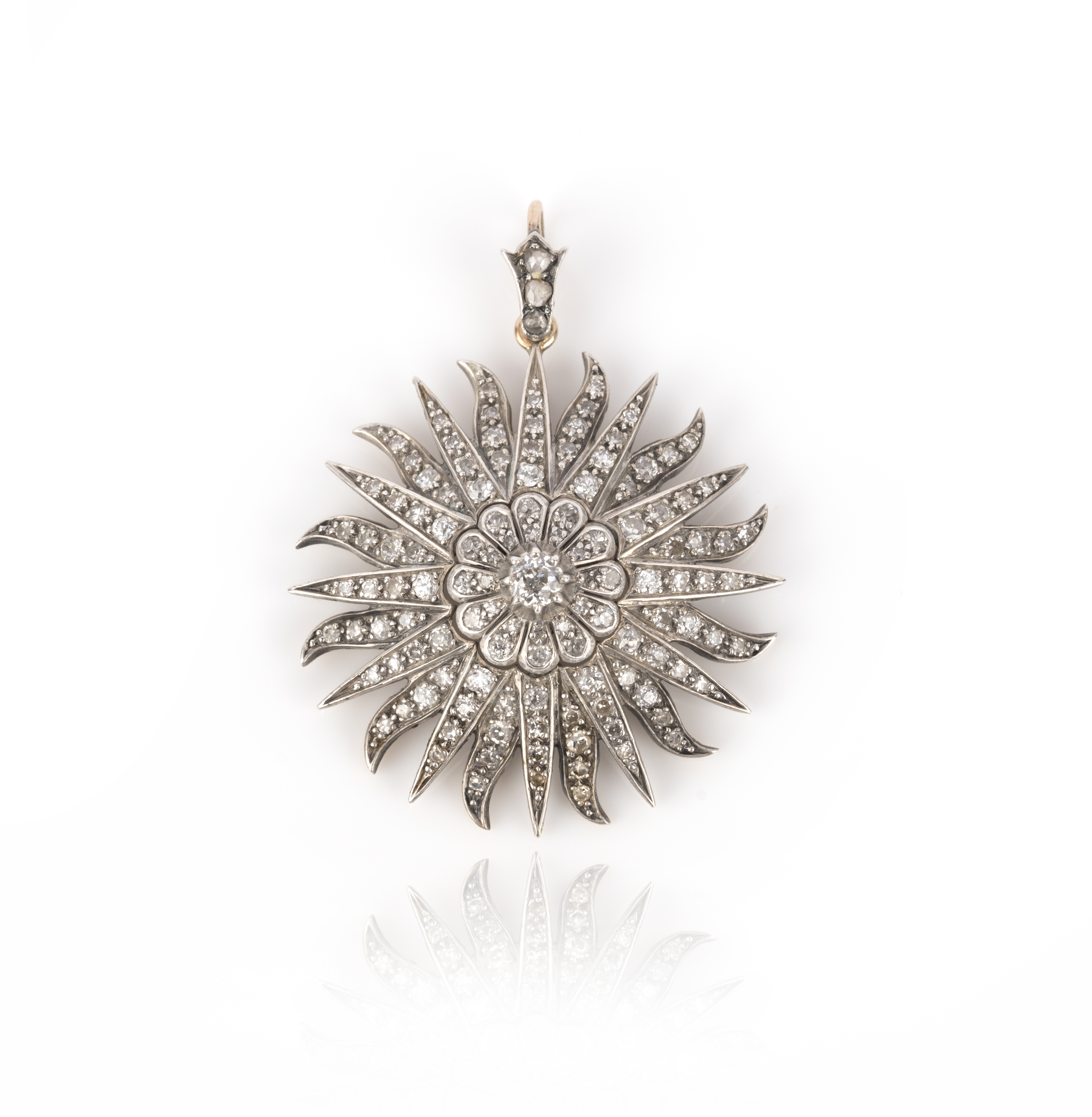 A late 19th century diamond starburst pendant, set with graduated old cushion-shaped diamonds in