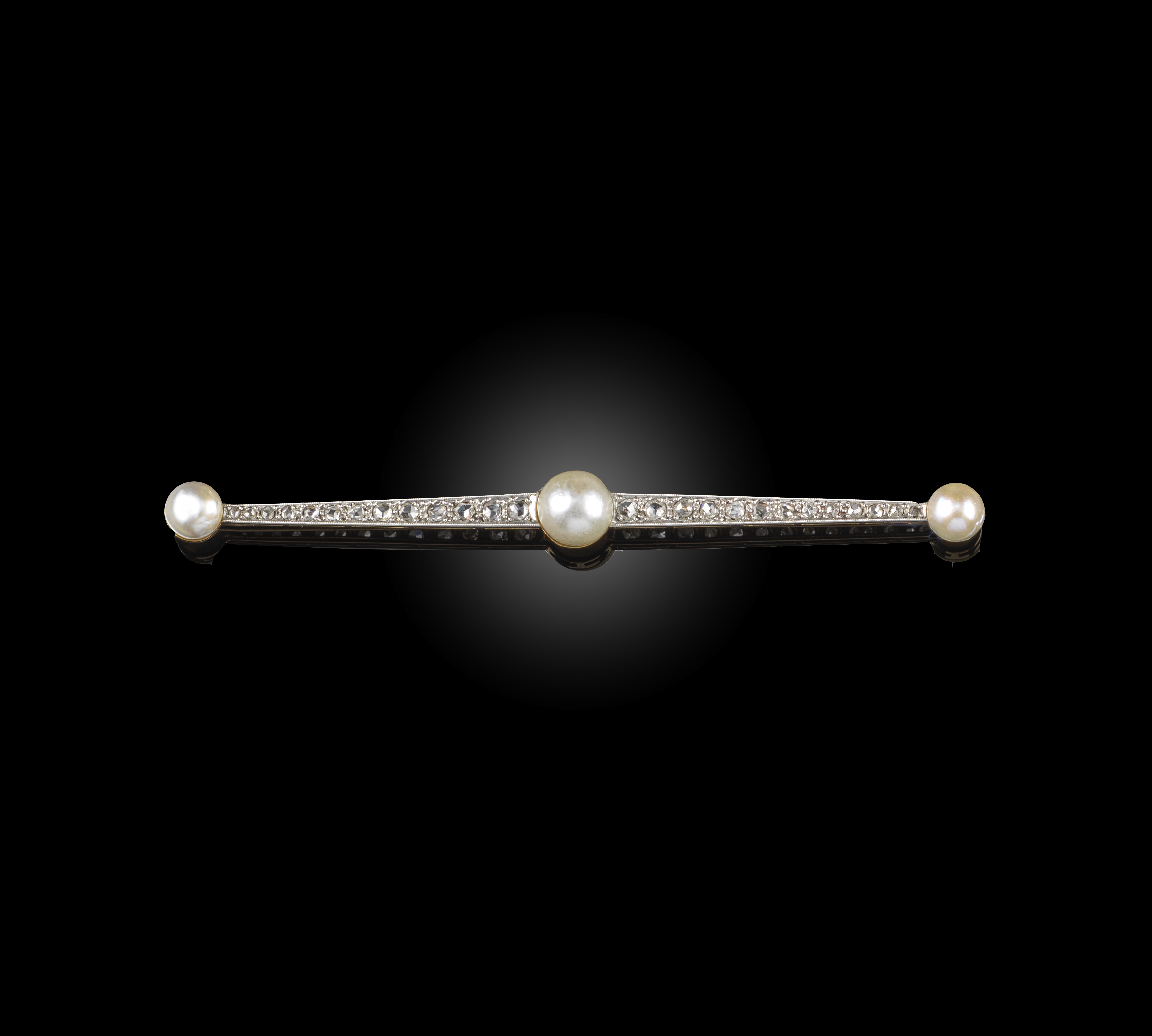 A pearl and diamond brooch, circa 1910, of bar design, set with rose-cut diamonds and three bouton-