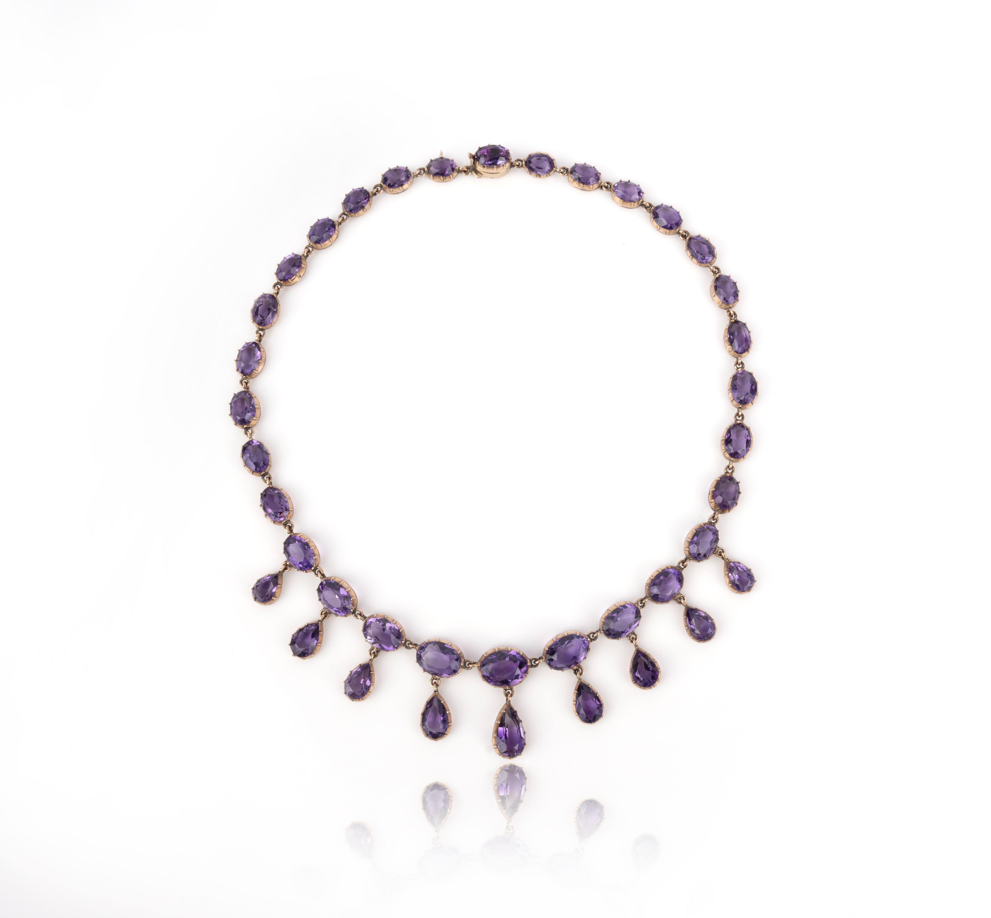 A Victorian amethyst riviere necklace, the oval graduated amethysts in gold cut-down collets suspend