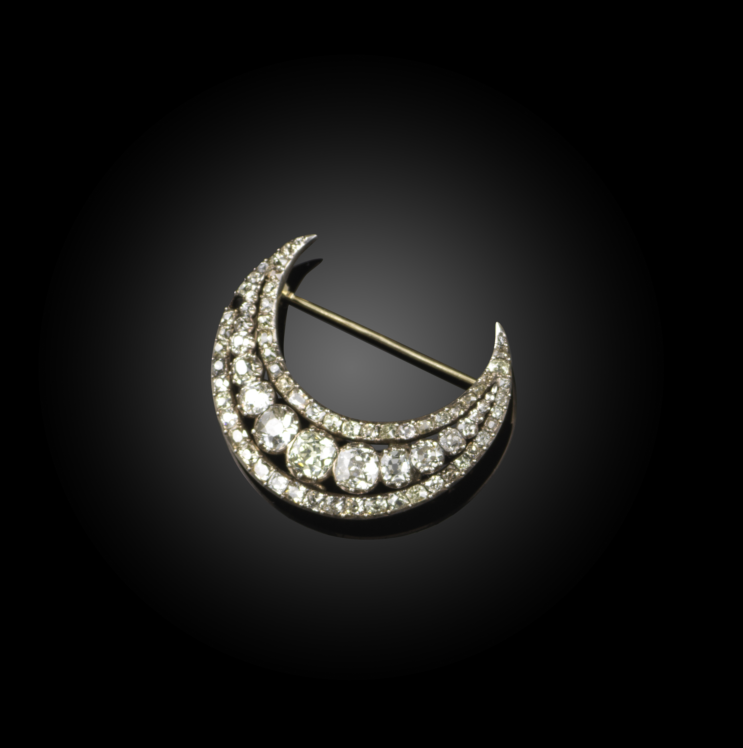 A diamond brooch, early 19th century, designed as a crescent moon, the centre with a row of