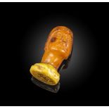 An unusual amber desk seal, the seal designed as the bust of a man wearing a cap, with chin-length
