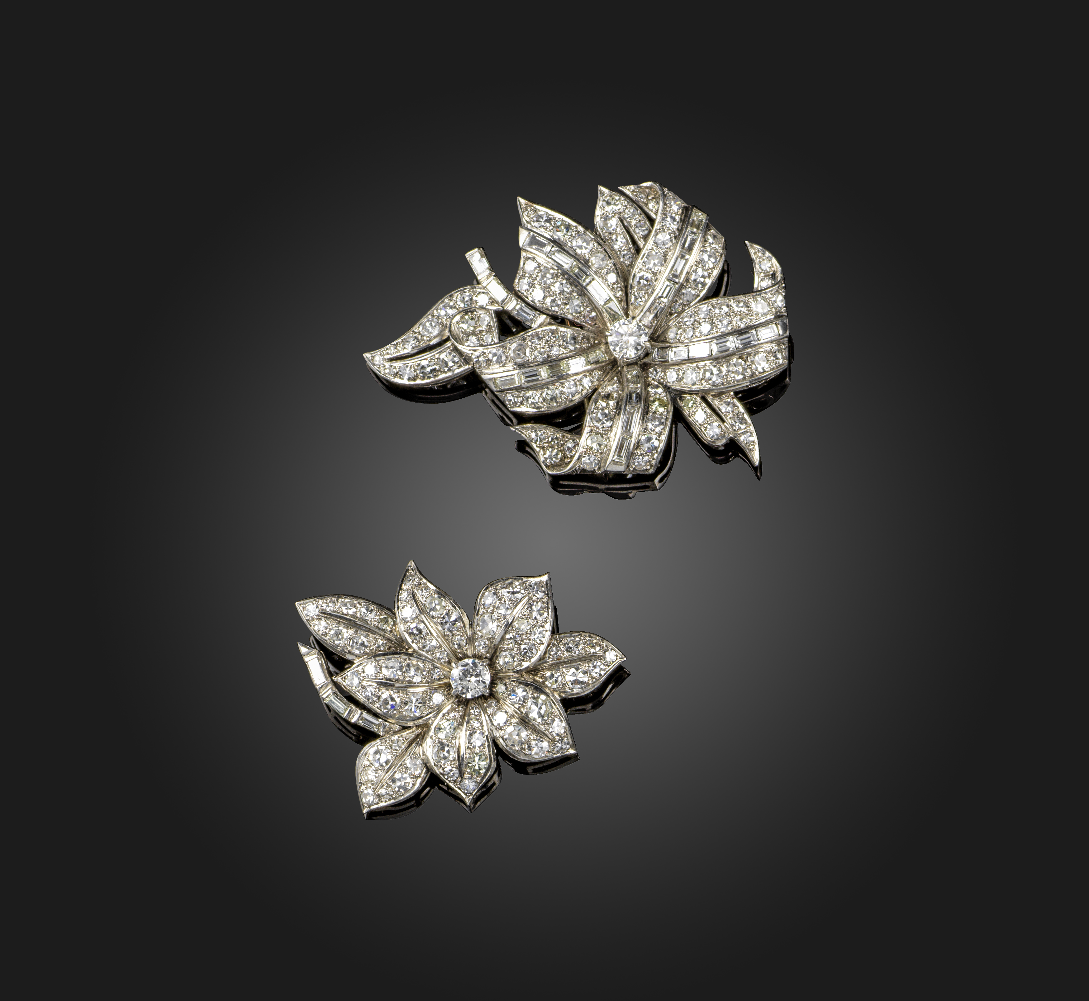 A pair of diamond brooches, 1950s, the asymmetrical brooches each designed as a flower, set with