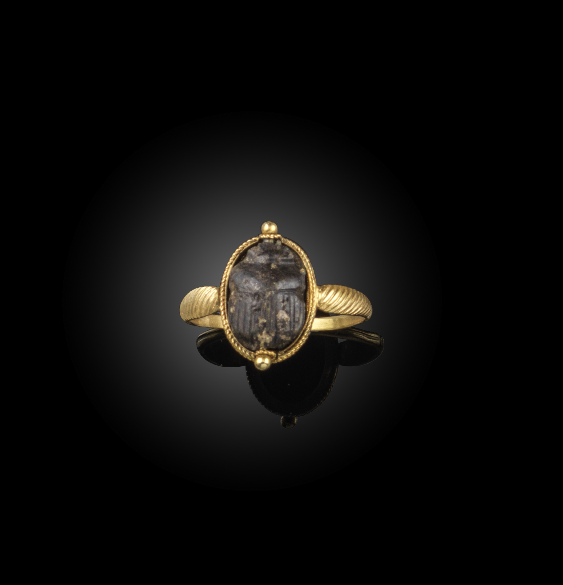 A stone scarab ring, 19th century, set with an Egyptian stone scarab, within a gold rope twist mount