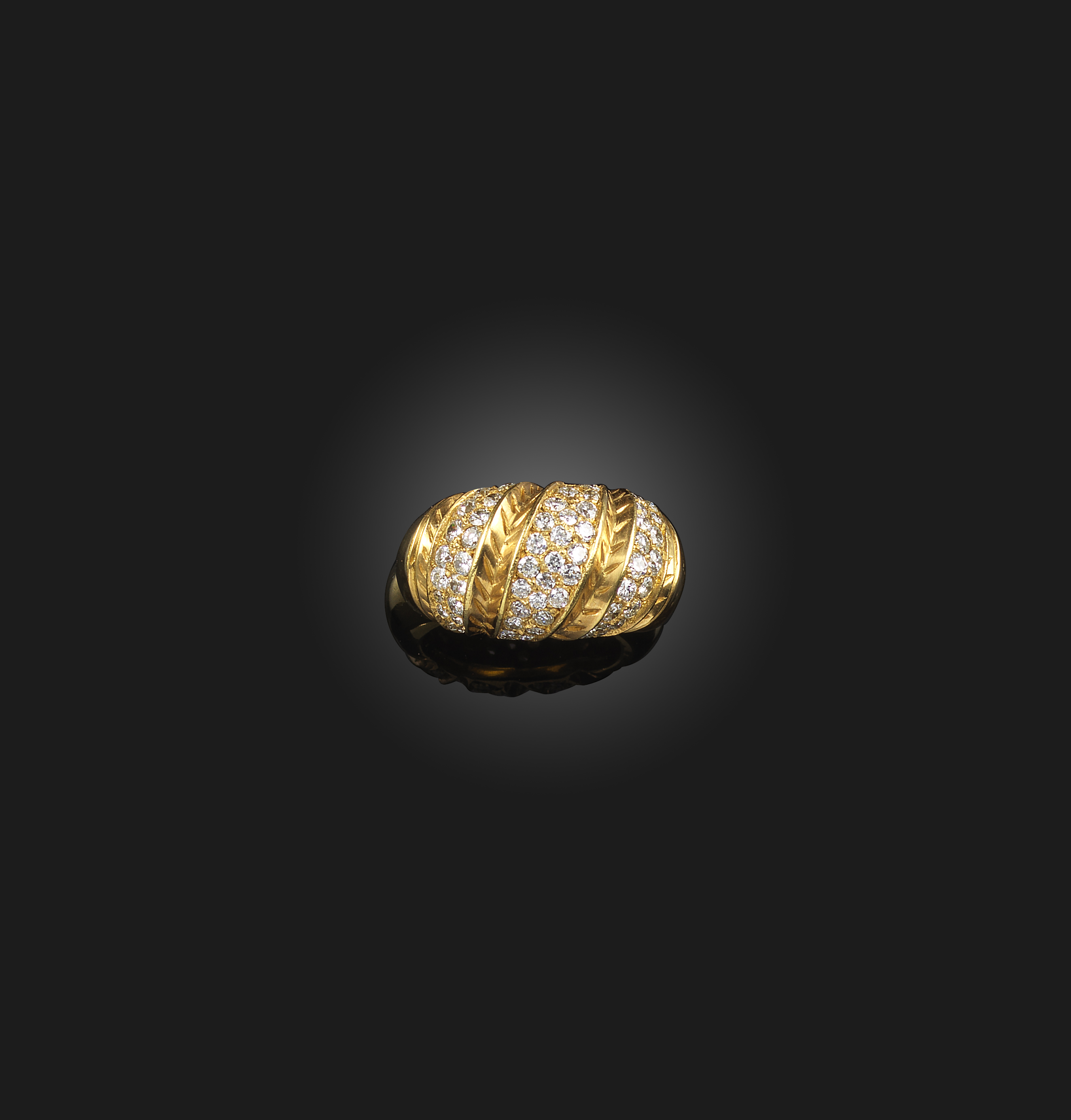 A diamond ring, of bombé form, the front of twist design, pavé-set with stripes of circular-cut