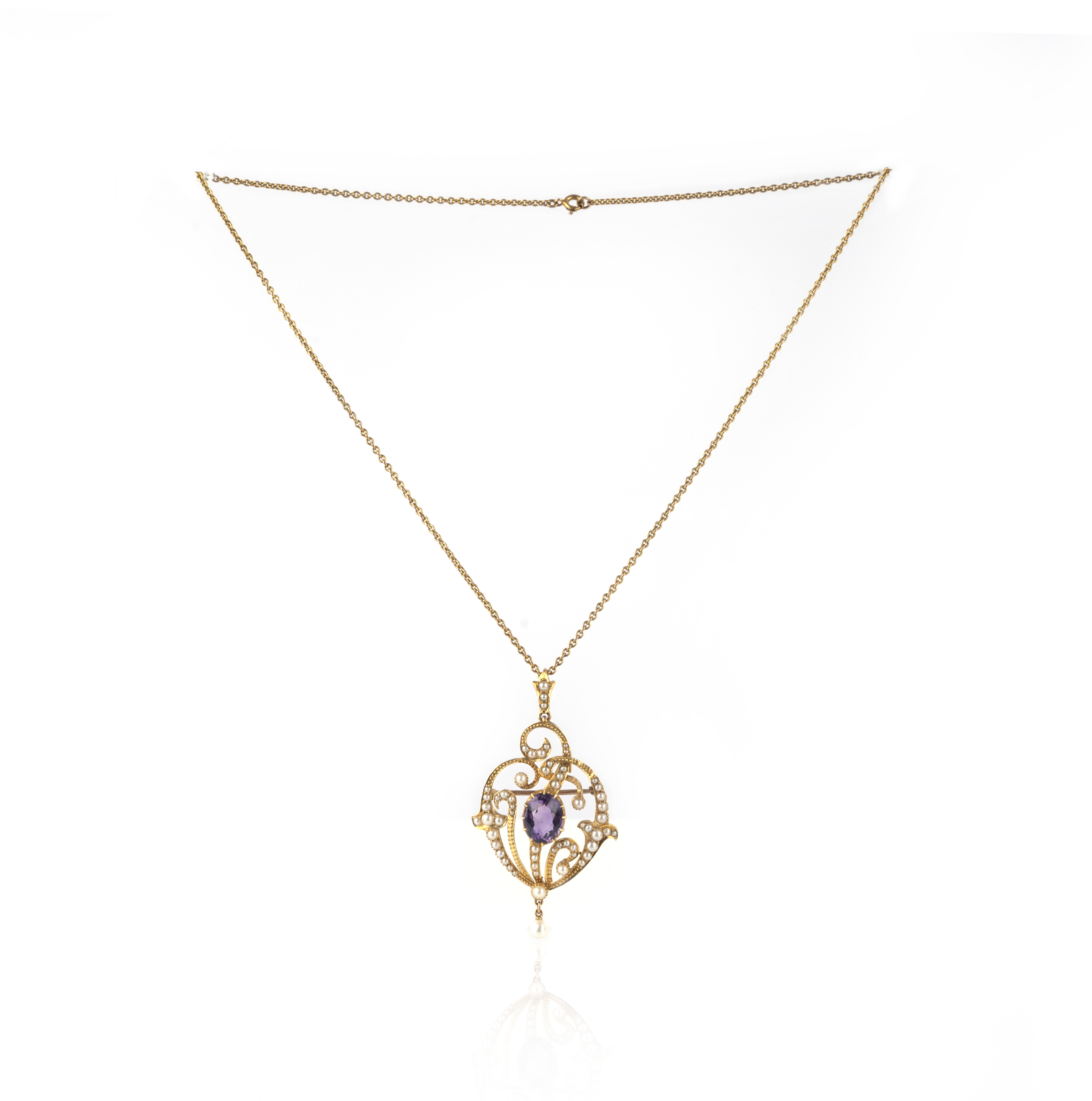 An Edwardian amethyst and seed pearl pendant, circa 1910, of asymmetrical design in the Art