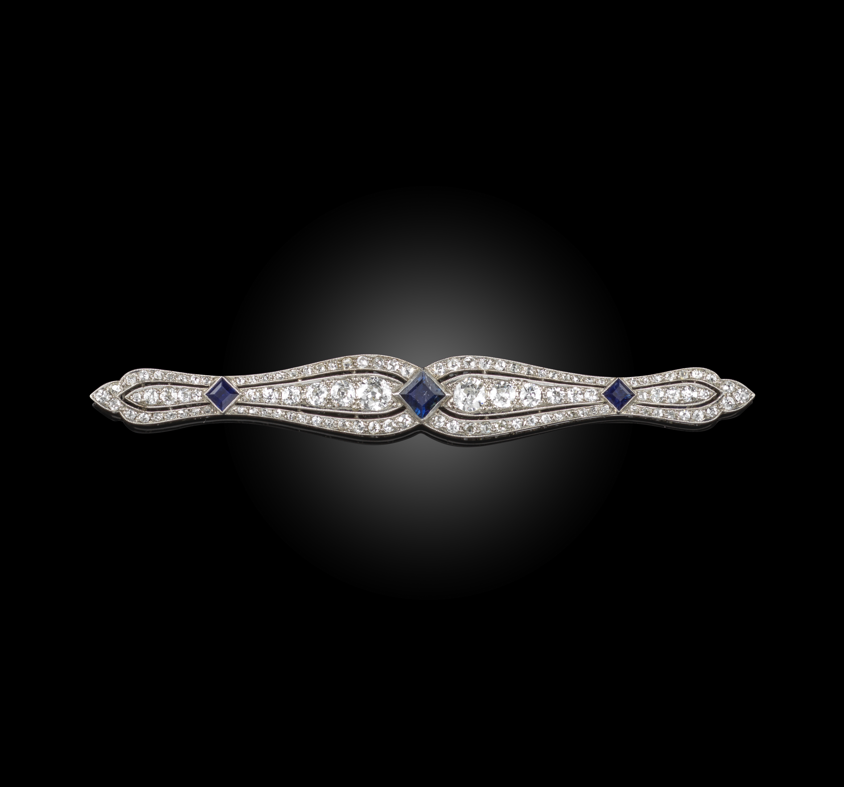 An early 20th century sapphire and diamond brooch, of sinous outline set with graduated old