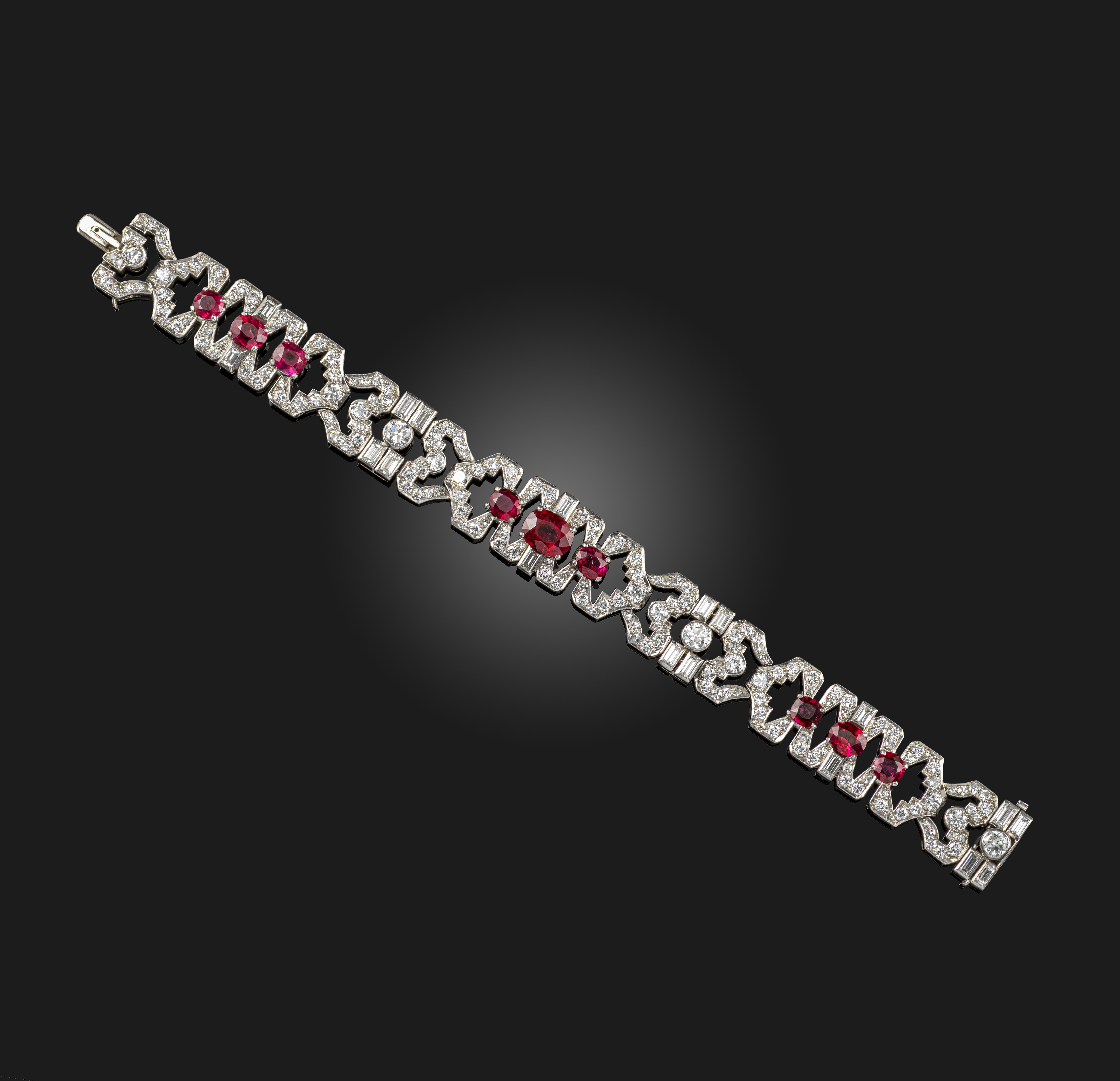 An Art Deco ruby and diamond bracelet, circa 1930, of geometric design, set with oval rubies and