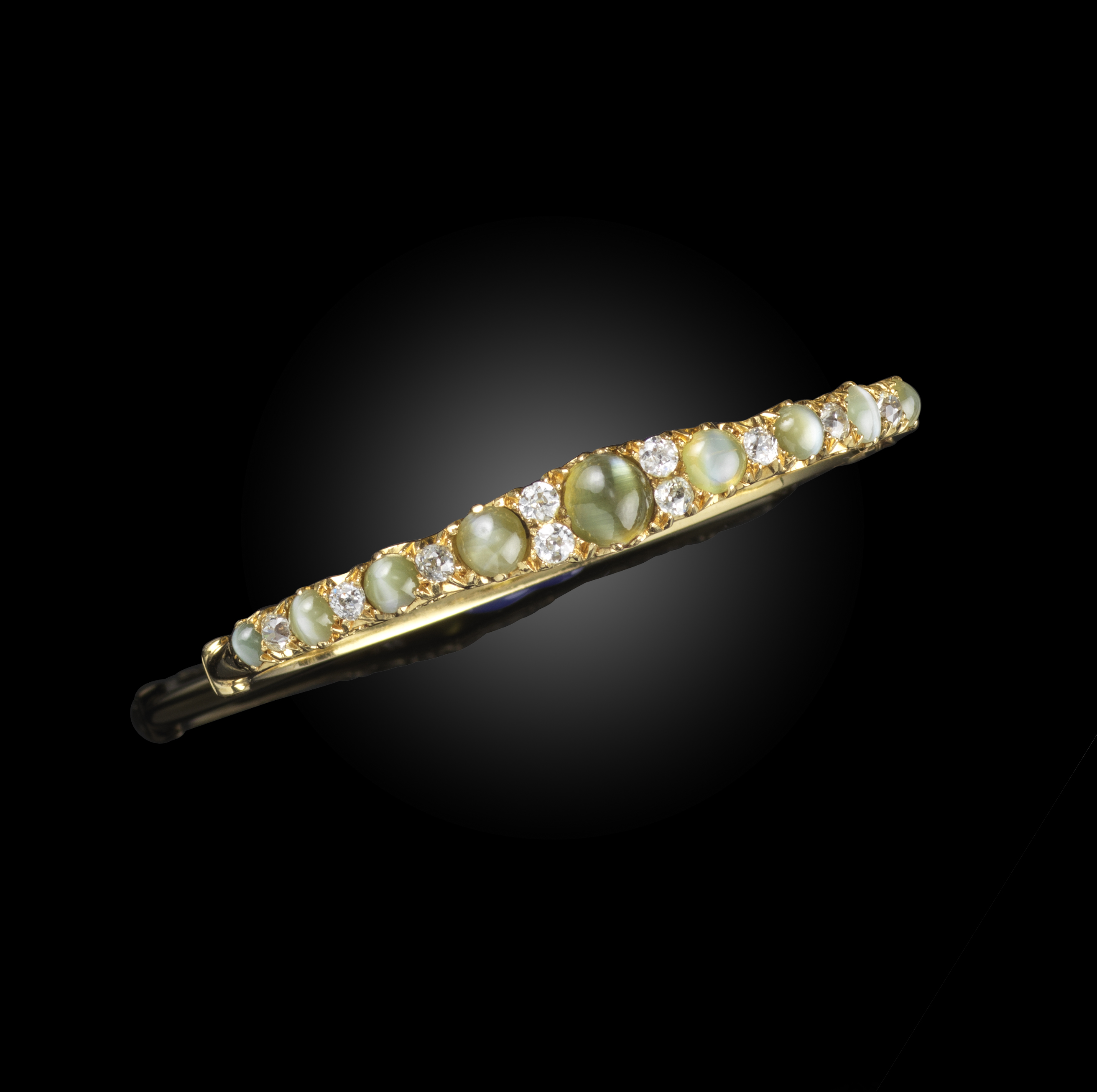 A Victorian cat's eye chrysoberyl and diamond bangle, late 19th century, of hinged design, the front