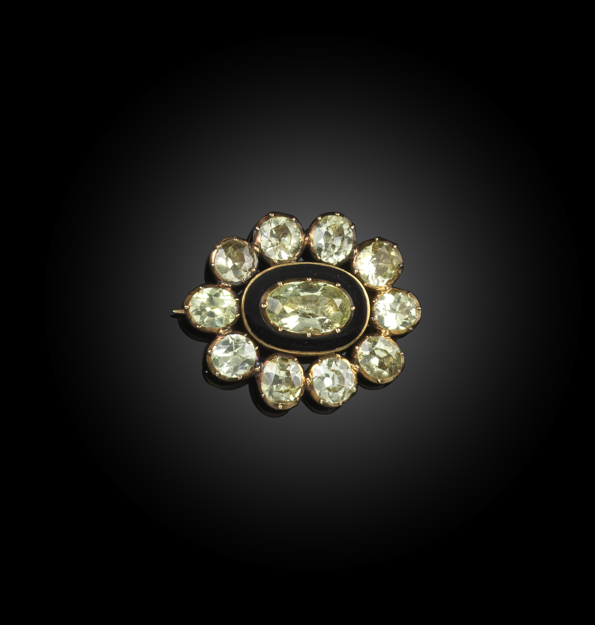 A late Georgian chrysoberyl and enamel mourning brooch, circa 1827, of oval outline, designed as a