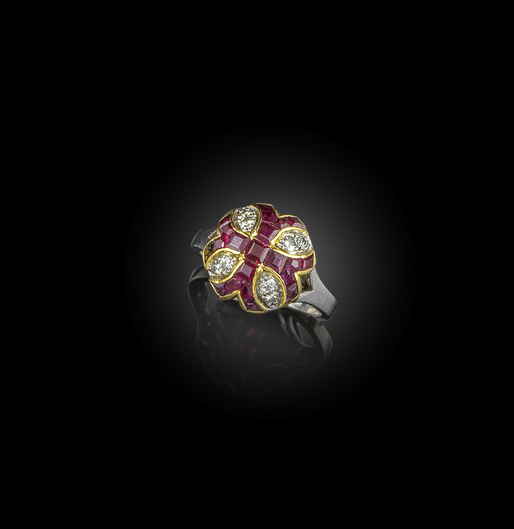 A ruby and diamond ring, designed as a cluster with a Templar cross in calibré-cut rubies, spaced by