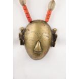 A Naga brass head pendant necklace Nagaland with seated figures to the sides and with strung glass