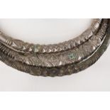 Three Nepal torques cast base metal and bronze with chiselled decoration, one with fibre binding,