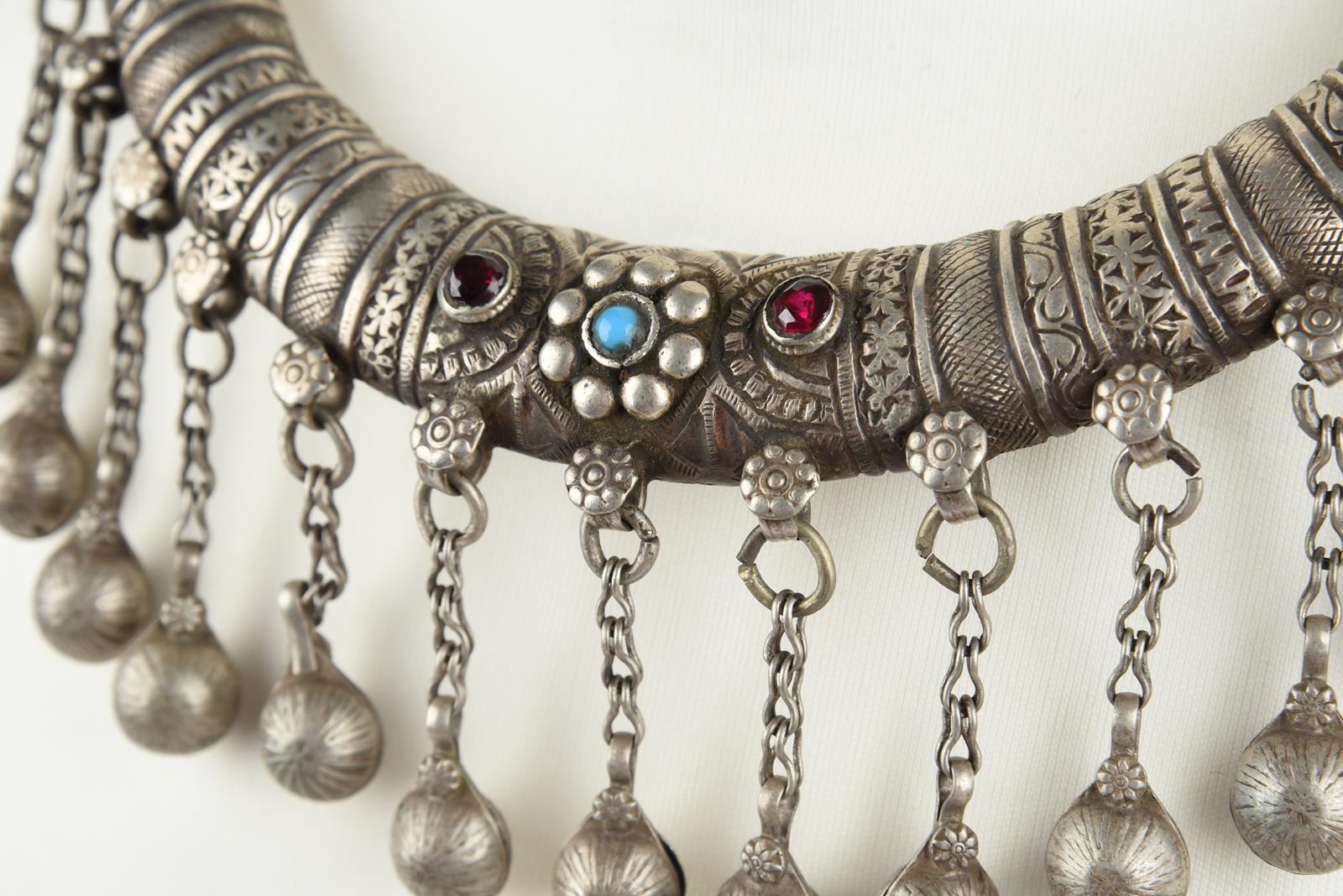 Three Nuristan torques silver coloured metal with applied blue stone and red and blue glass beads, - Image 18 of 19