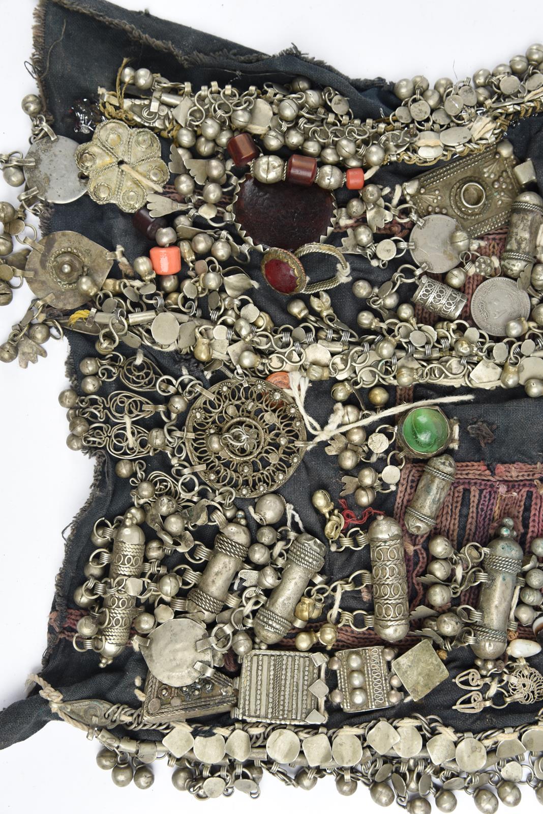 λA Bedouin amulet chest ornament cloth with numerous sewn on amulets and beads, 62cm long, and three - Image 23 of 27