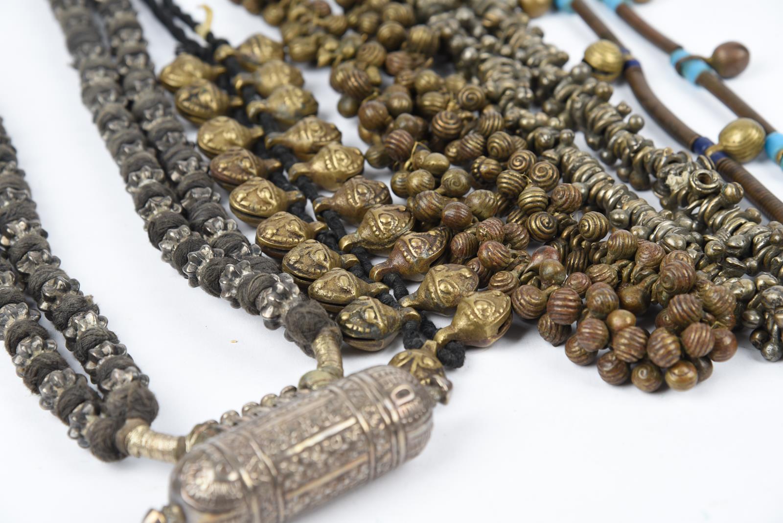 Five Nepal metal mounted necklaces including one with an amulet box and a double strand with cog