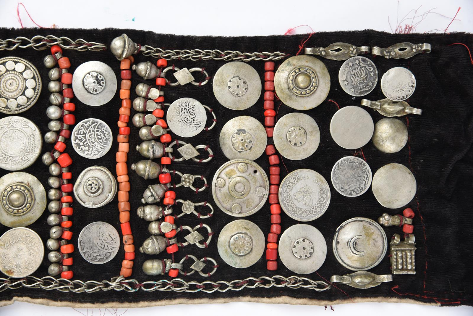 λA Bedouin amulet chest ornament cloth with numerous sewn on amulets and beads, 62cm long, and three - Image 18 of 27