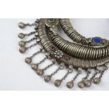 Three Nuristan torques silver coloured metal with applied blue stone and red and blue glass beads,