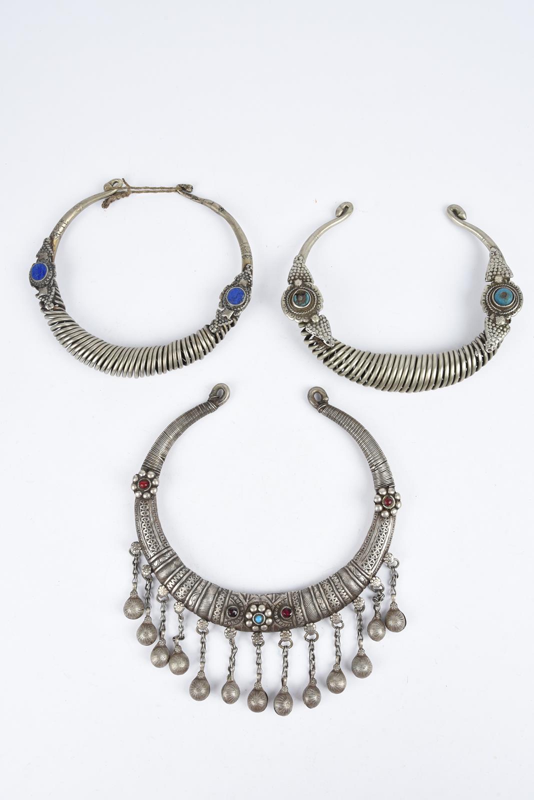 Three Nuristan torques silver coloured metal with applied blue stone and red and blue glass beads, - Image 2 of 19