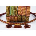 A pair of Naga armbands Nagaland dyed and natural fibre, each of three bands bound with leaf to