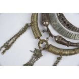 Four Indian torques silver coloured metal, including a hanswi with chains, 20cm wide, another with