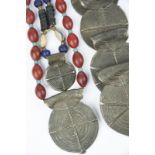 A Naga bead necklace Nagaland glass beads and shell with a cast brass onyop pendant, 41cm long,