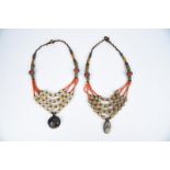 λTwo Tibetan necklaces with coral and glass beads and with copper mount pendants, the larger