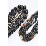 Nine South East Asian necklaces glass, agate, nut shell, shell, white metal, copper and wood, one