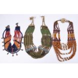 Three Naga necklaces Nagaland coloured glass beads, brass, shell and fibre, one hung with brass