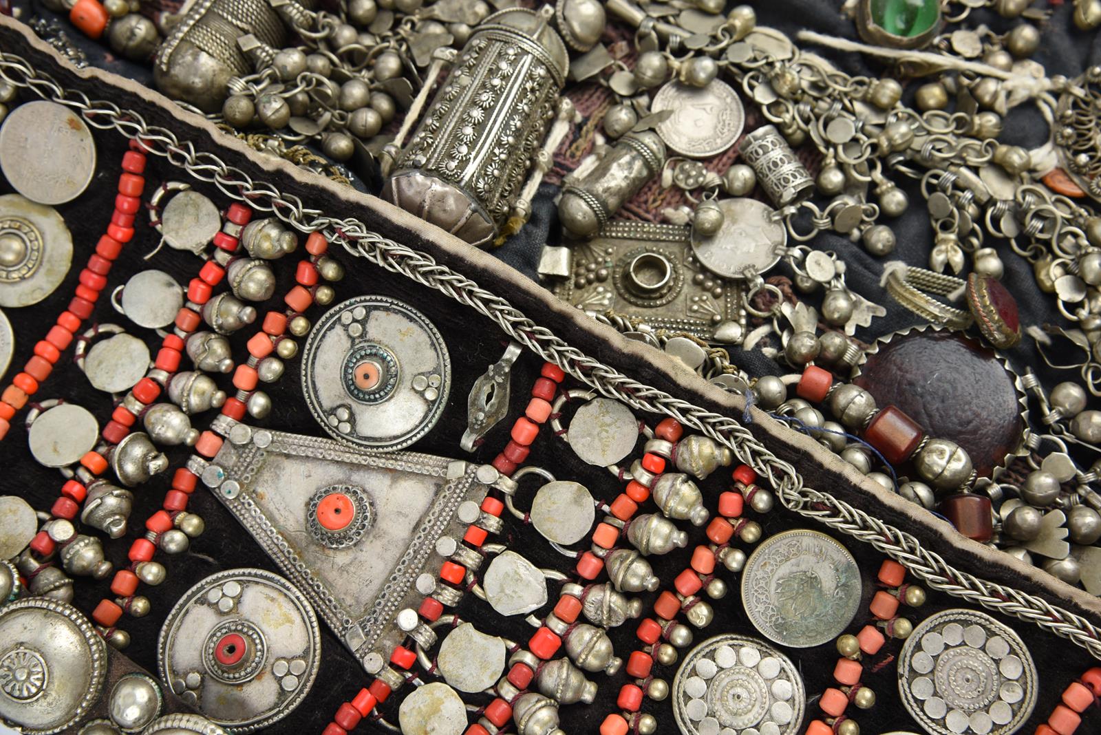 λA Bedouin amulet chest ornament cloth with numerous sewn on amulets and beads, 62cm long, and three
