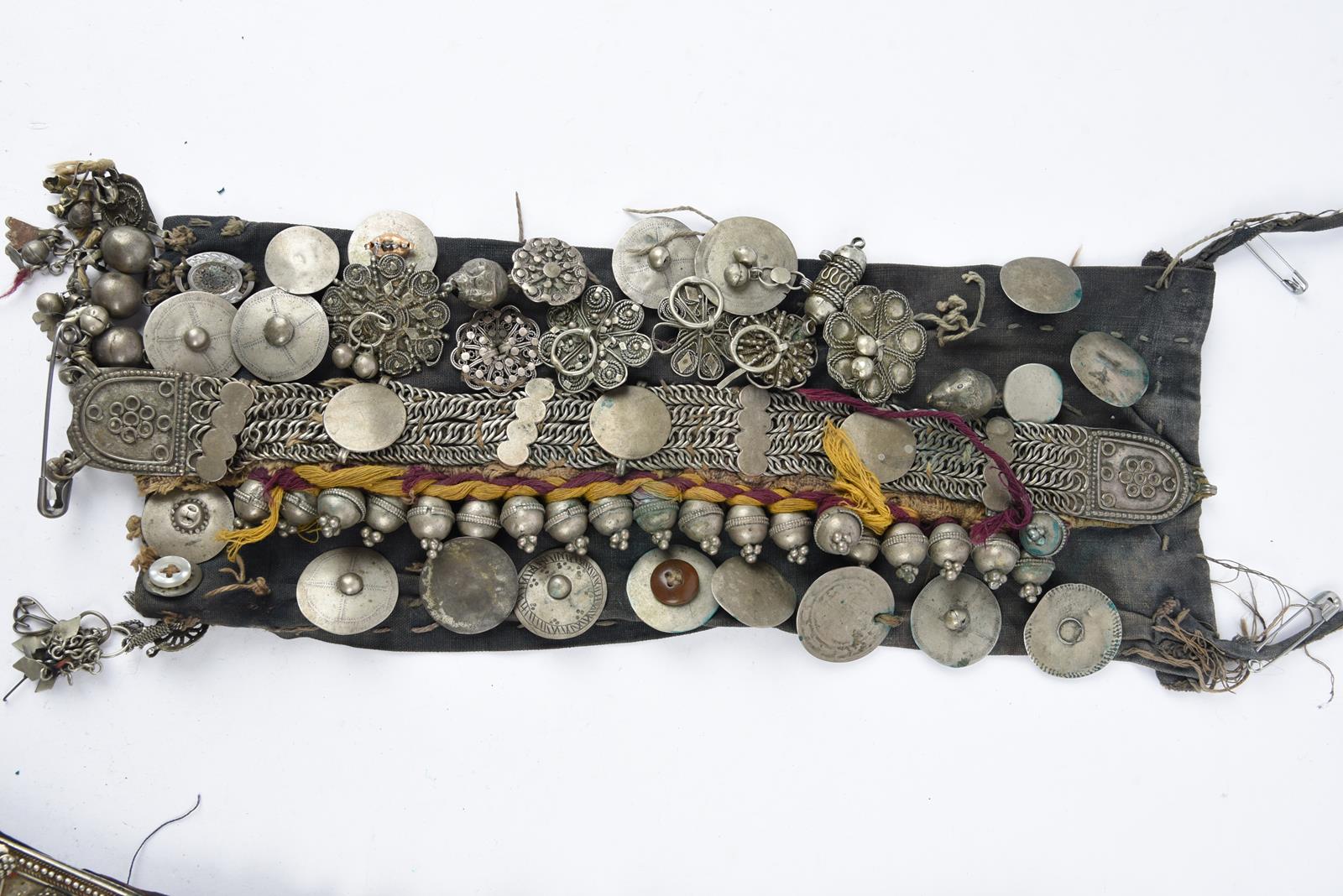 λA Bedouin amulet chest ornament cloth with numerous sewn on amulets and beads, 62cm long, and three - Image 8 of 27