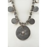 An Omani necklace silver coloured metal with eight Maria Theresa thalers and a large disc pendant