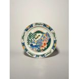 A large Delft plate or charger, c.1720, painted in blue, red, green and yellow with a kylin