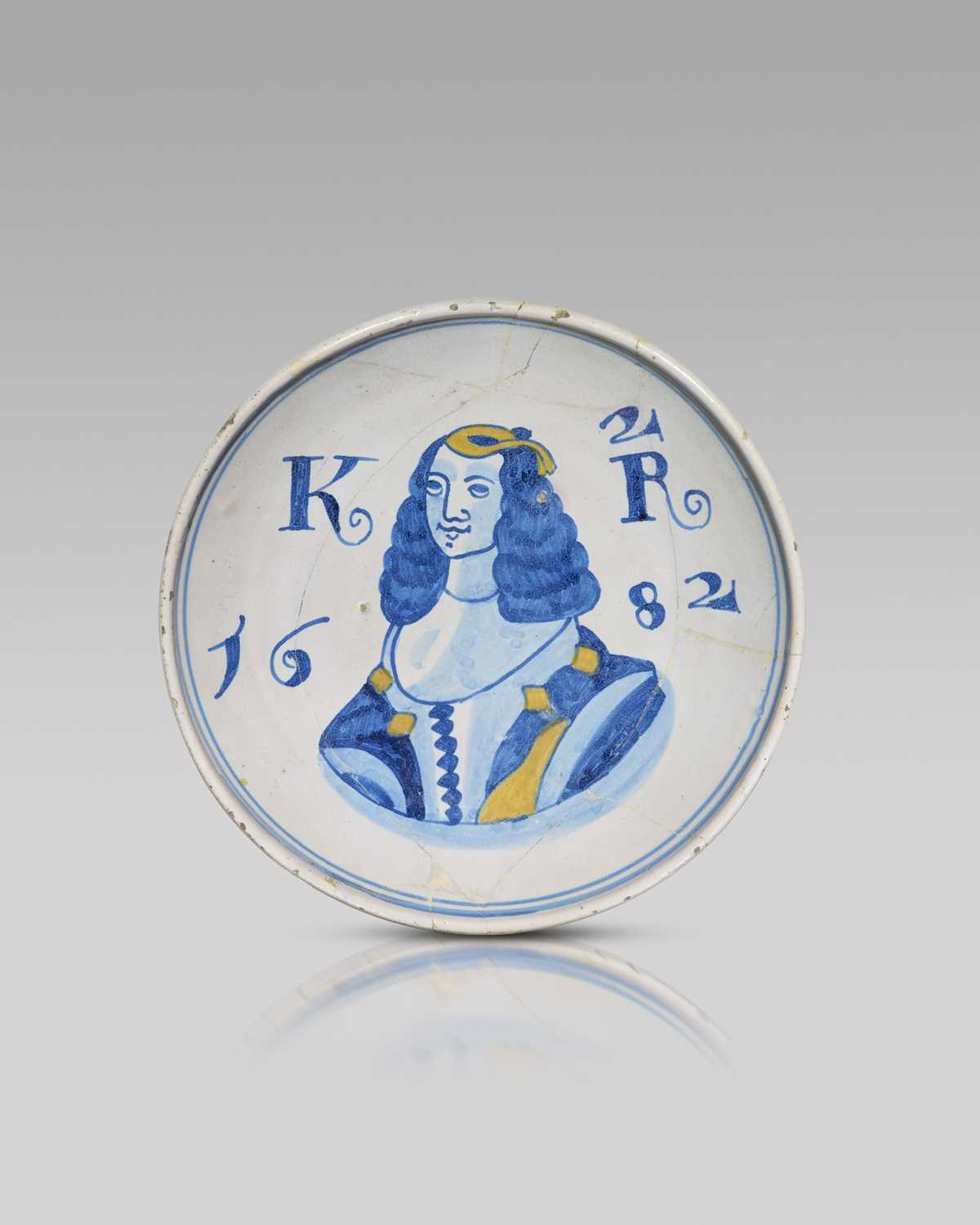 A rare delftware Royal dish, dated 1682, painted in blue and yellow with a portrait of Catherine