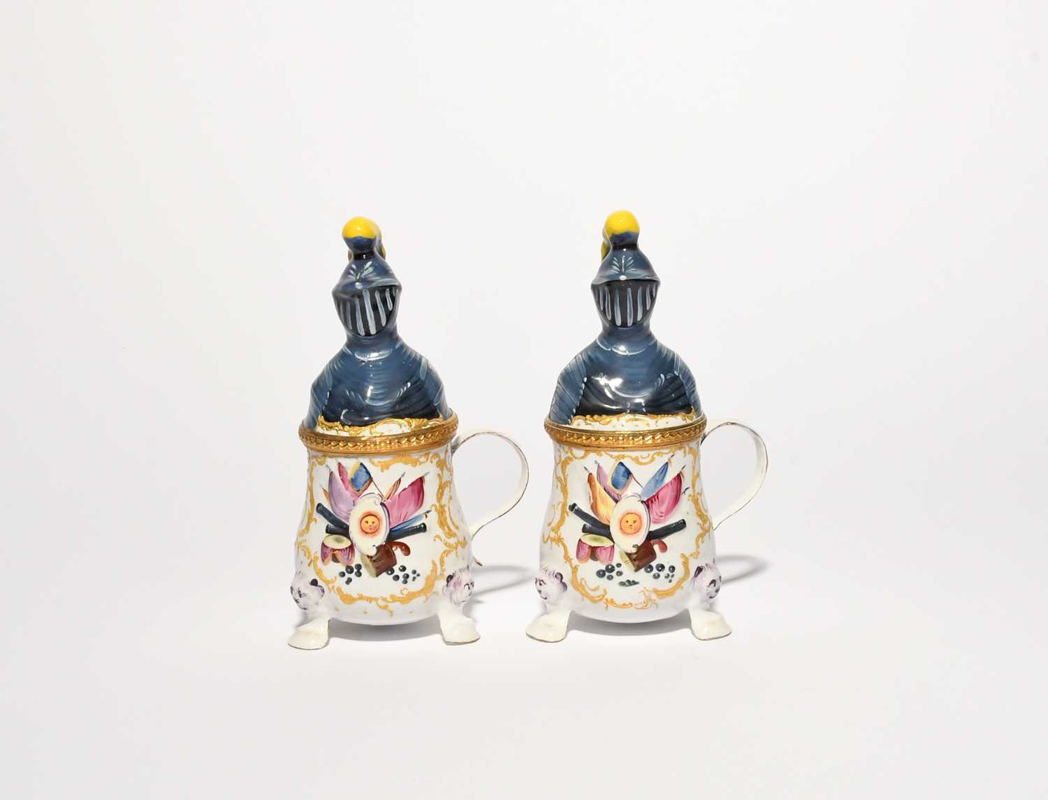 A pair of Bilston enamel mustard pots and covers, c.1780, each modelled as a knight in armour with a