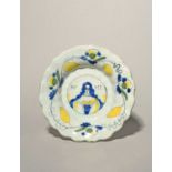 A small Delft lobed portrait dish, c.1685-89, painted in blue, black, green and yellow with the