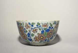 A massive Delft punch bowl, 18th century, boldly painted in polychrome enamels with flowering plants