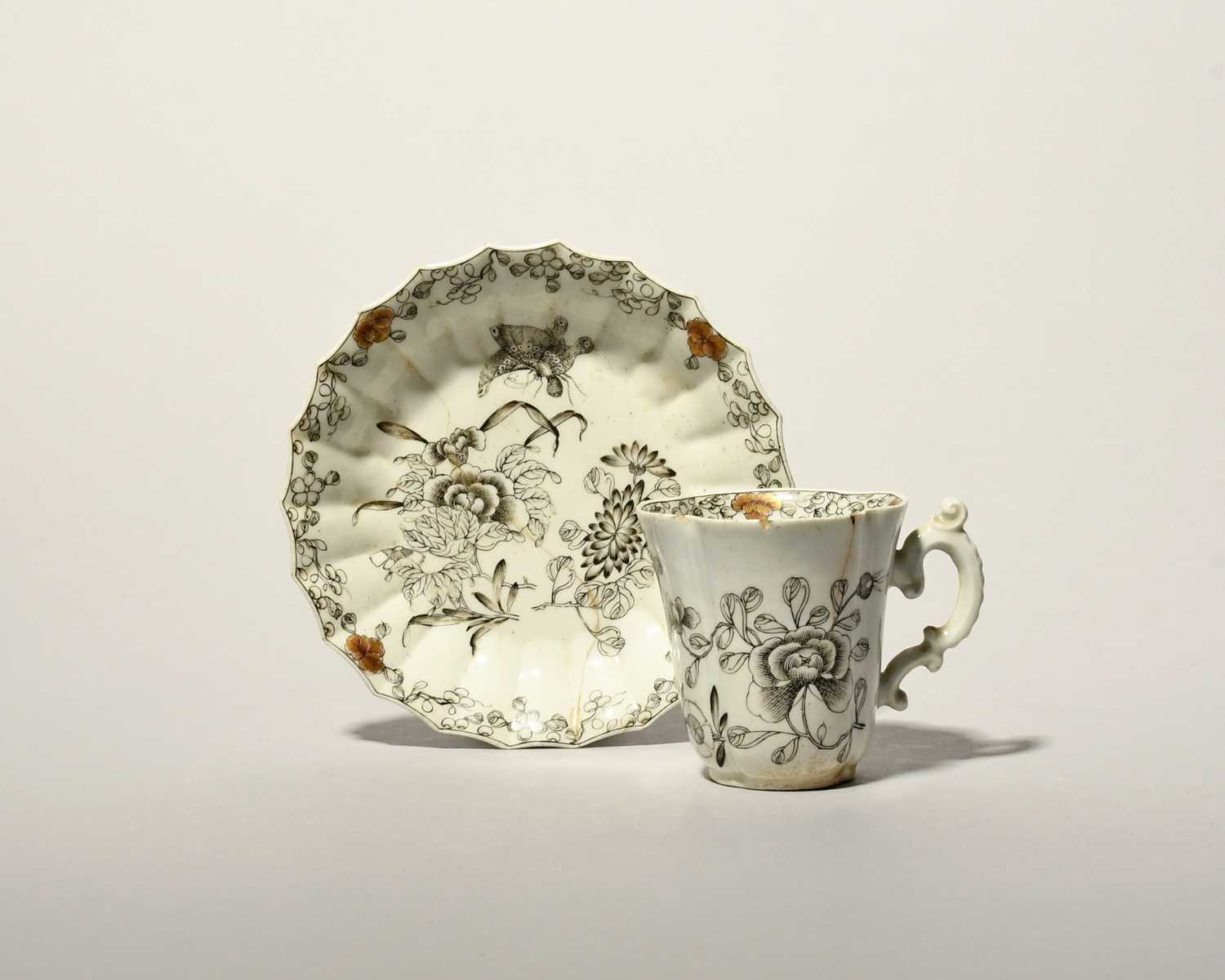 A rare Worcester coffee cup and saucer, c.1753-54, the cup of quatrefoil form with an elaborate