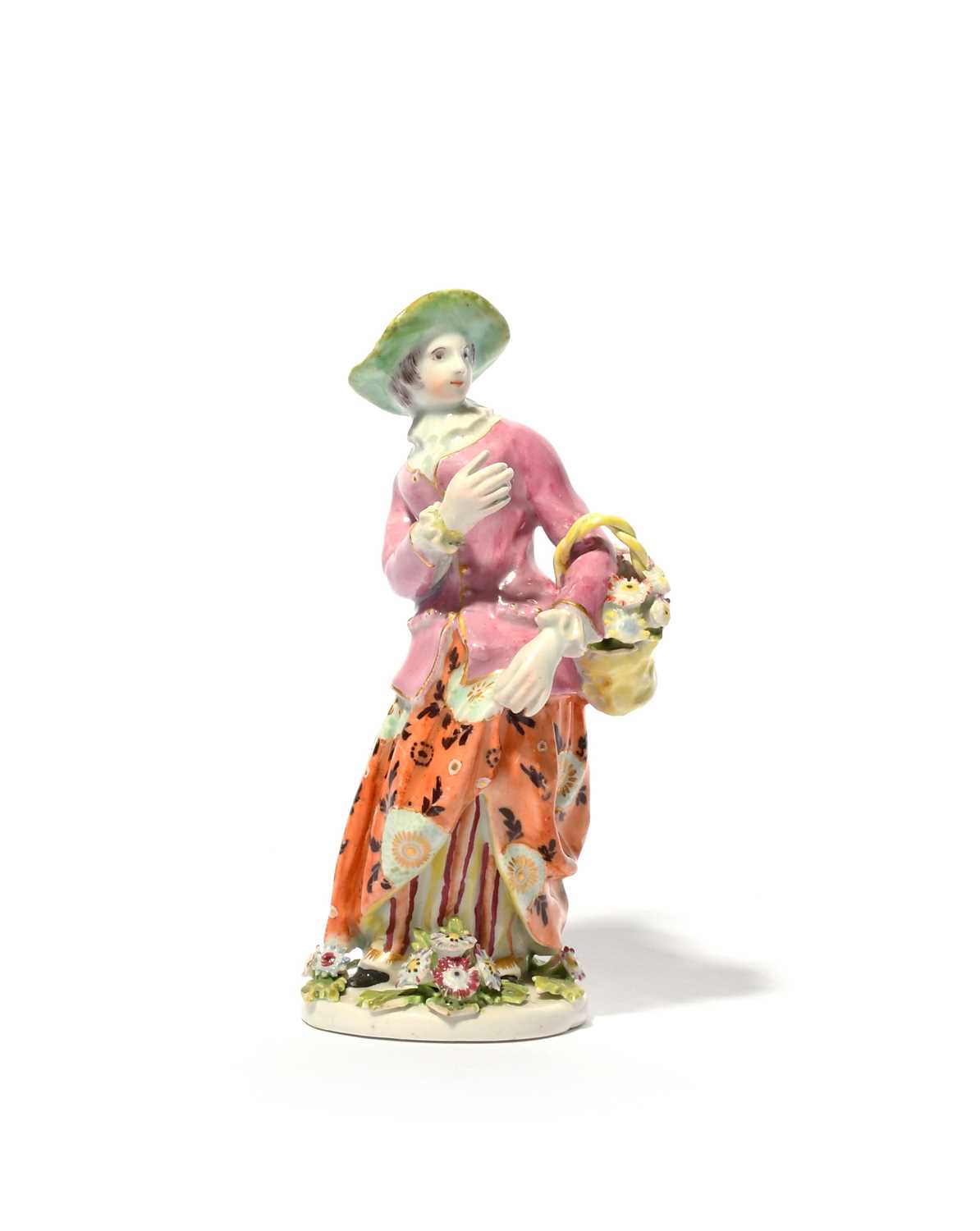 A Bow figure of a flower girl, c.1755, standing with a basket of flowers over her left arm,