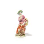 A Bow figure of a flower girl, c.1755, standing with a basket of flowers over her left arm,