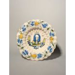 A Delft Royal lobed dish or charger, c.1690, moulded with rows of narrow flutes, painted in blue,